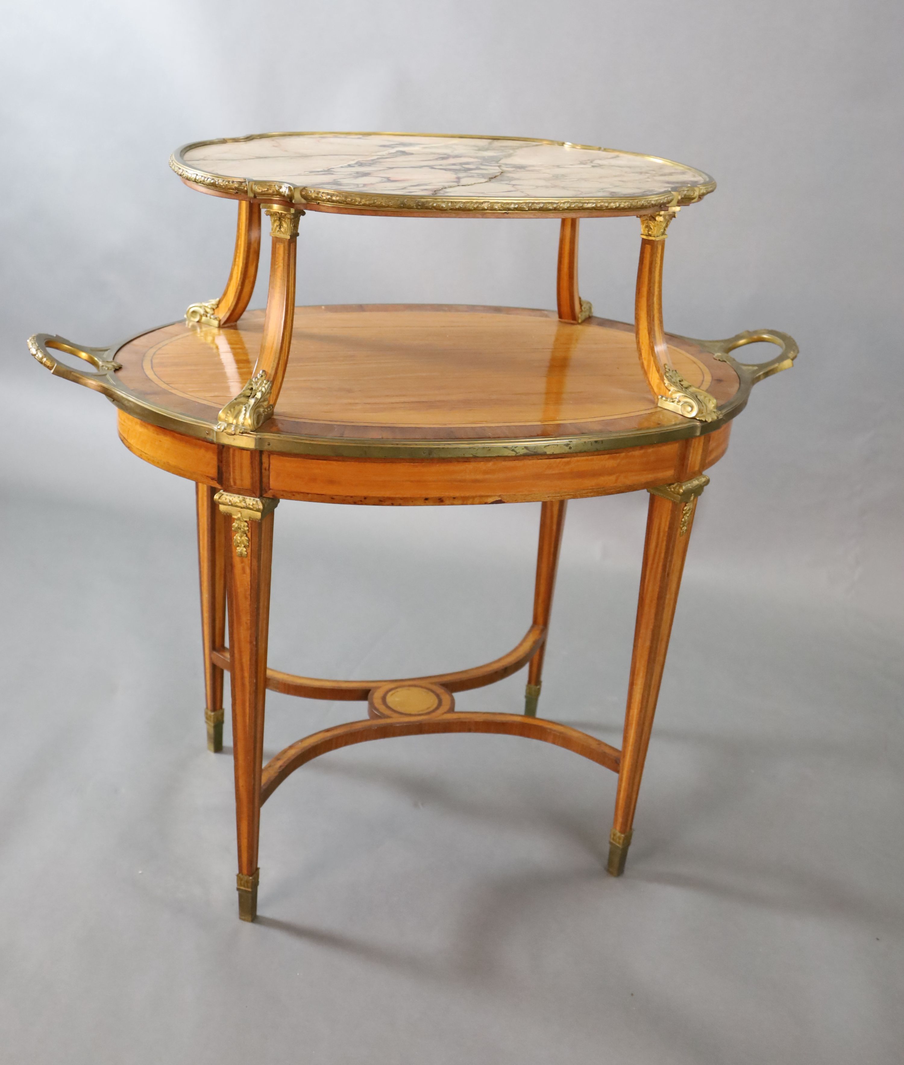 A late 19th century French satinwood, rosewood crossbanded and gilt metal mounted two tier oval etagere, W.3ft 4.5in. D.2ft H.3ft 3in.